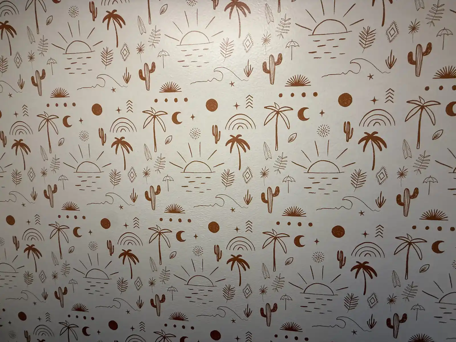 Playful illustrated wallpaper pattern with palms, cacti, suns, and waves