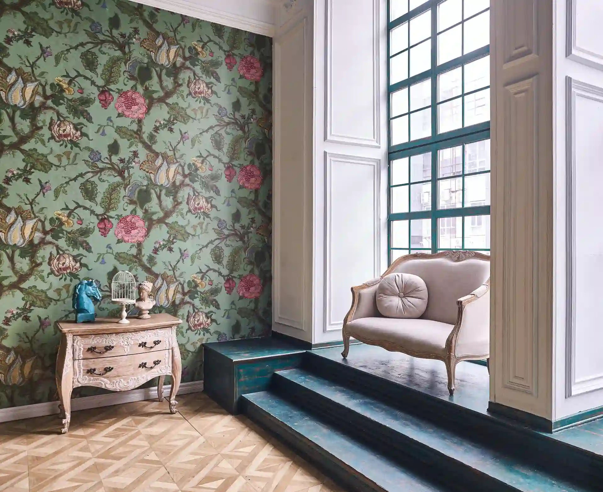Floral wallpaper on an entry wall beside a vintage chair and tall window